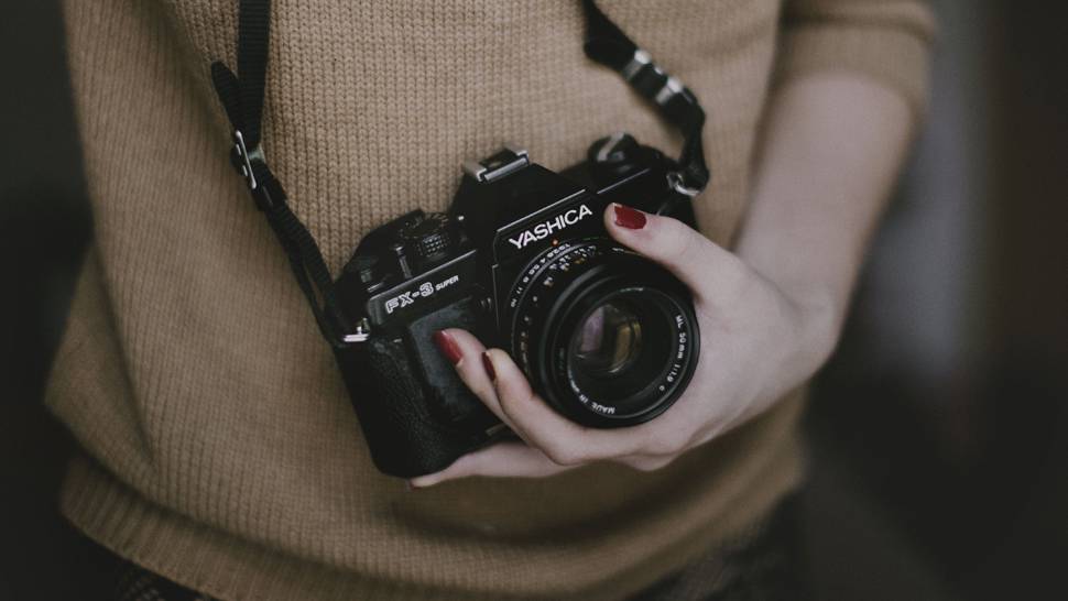 黒いカメラを持つ女性の手元のクールな写真
