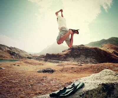 大自然の山の中でジャンプする男性の写真