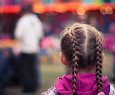 遊園地のお下げ髪の女の子の後ろ姿の写真