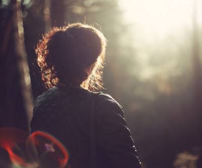 森の中の女性を逆光で撮影した綺麗な写真