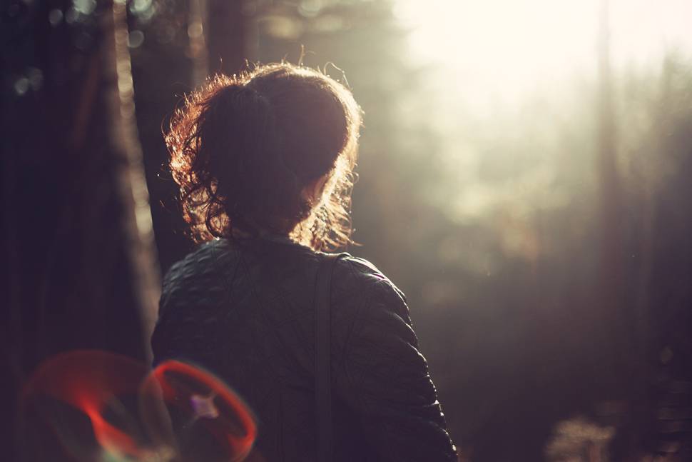 森の中の女性を逆光で撮影した綺麗な写真