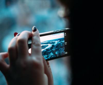 スマートフォンで撮影する女性の手元の写真
