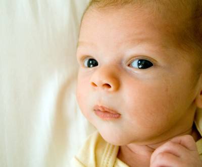 黒目がちな潤んだ瞳で見つめる赤ちゃんの写真
