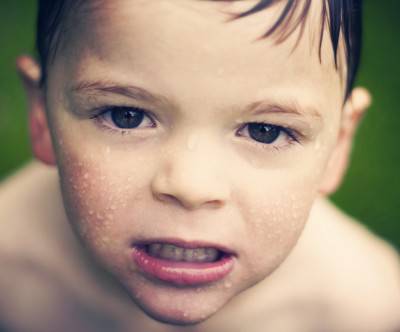 プールに入った険しい顔の少年の写真