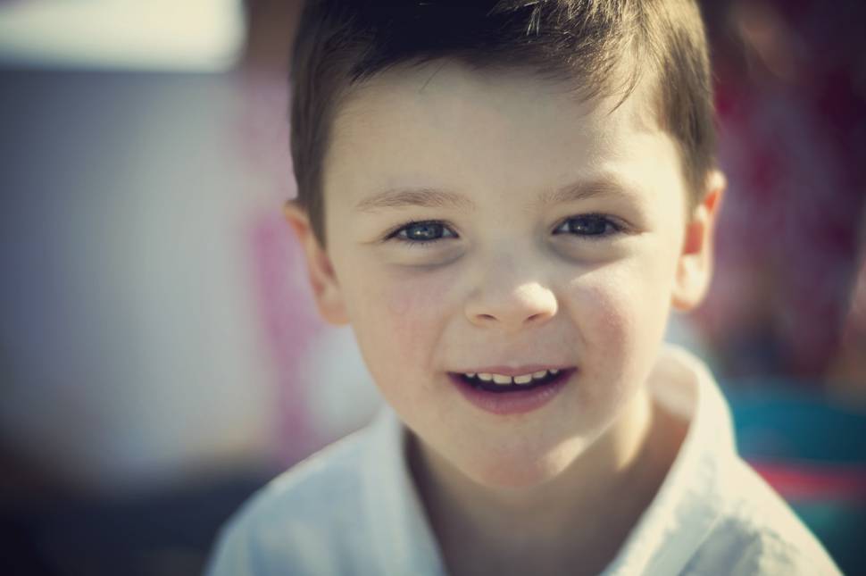 柔らかいボケで笑顔の少年を撮影した写真