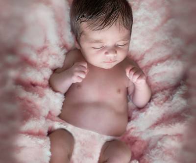 胎児のポーズで眠る赤ちゃんの神秘的な写真
