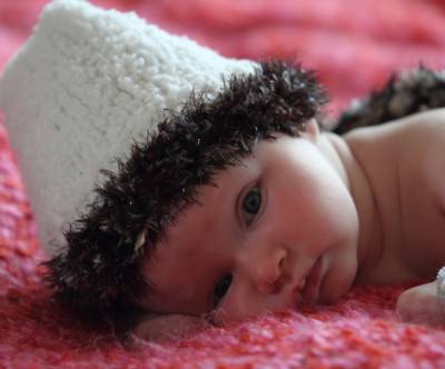 ファー付きの帽子をかぶった赤ちゃんの写真