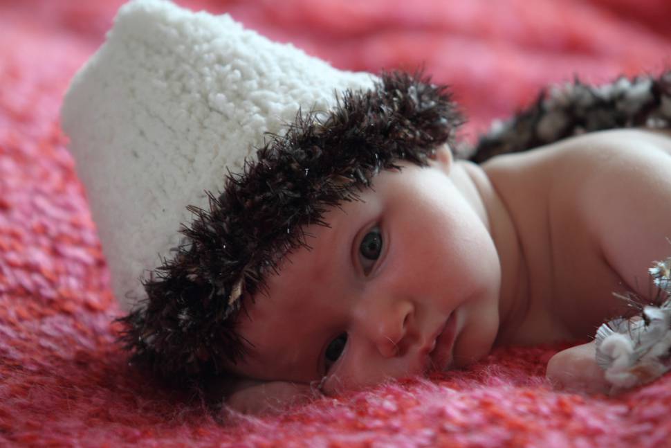 ファー付きの帽子をかぶった赤ちゃんの写真