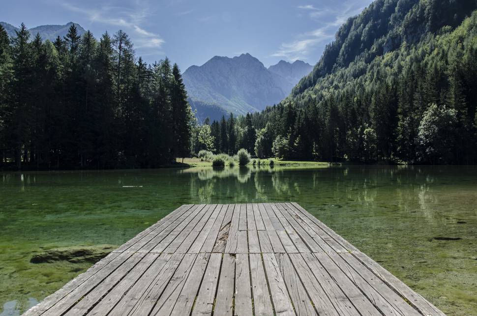 透明度の高い湖の桟橋と森と山の美しい写真