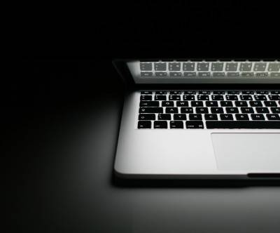 暗闇で光るMacBookProのモノクロ写真