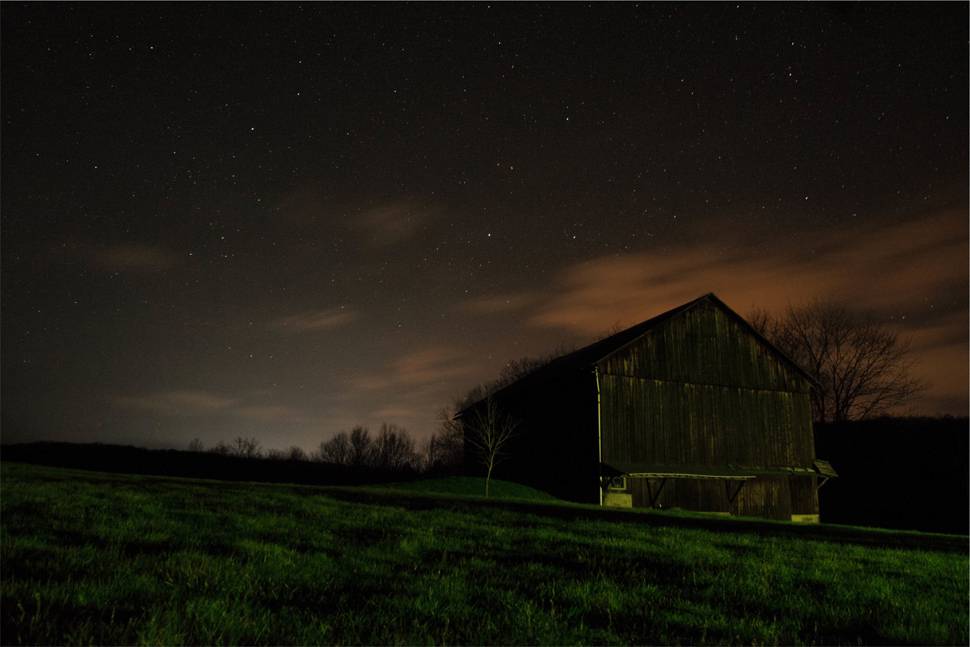 夜空の星と草原のキャビンの綺麗な写真