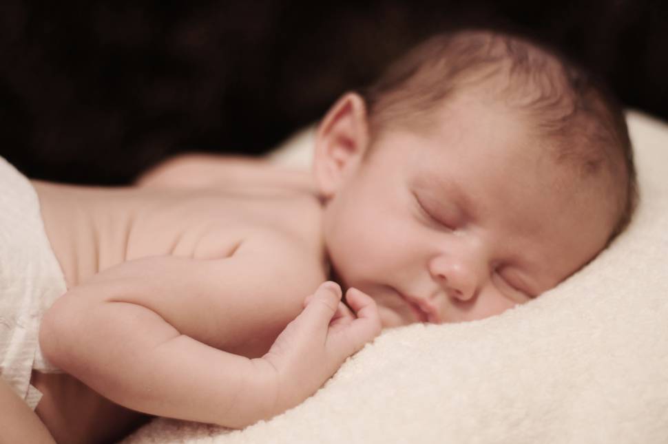 うつ伏せで眠るオムツを履いた赤ちゃんの写真