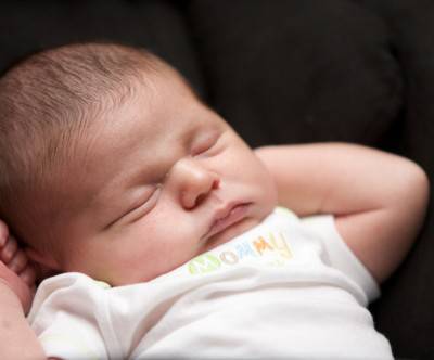 黒いソファーで眠る赤ちゃんの可愛い写真