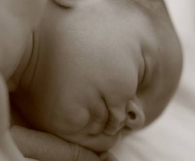 ベッドでぐっすり眠る赤ん坊のモノクロ写真