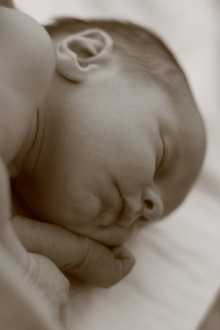 ベッドでぐっすり眠る赤ん坊のモノクロ写真