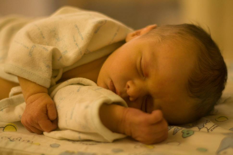 病院で眠るパジャマ姿の赤ちゃんの写真