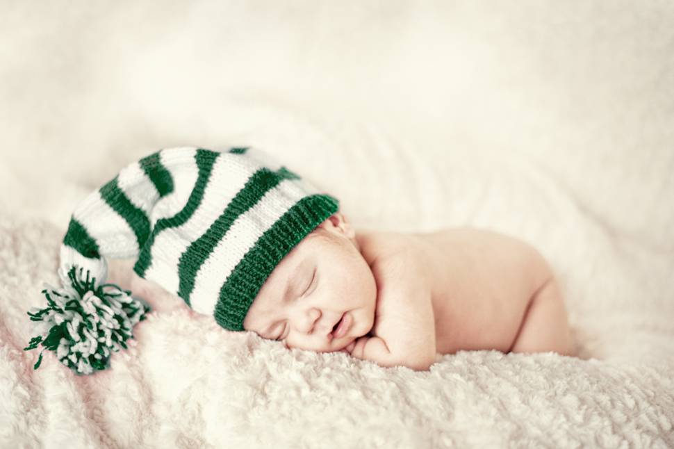 ボーダーのニット帽を被って眠る赤ちゃんの写真