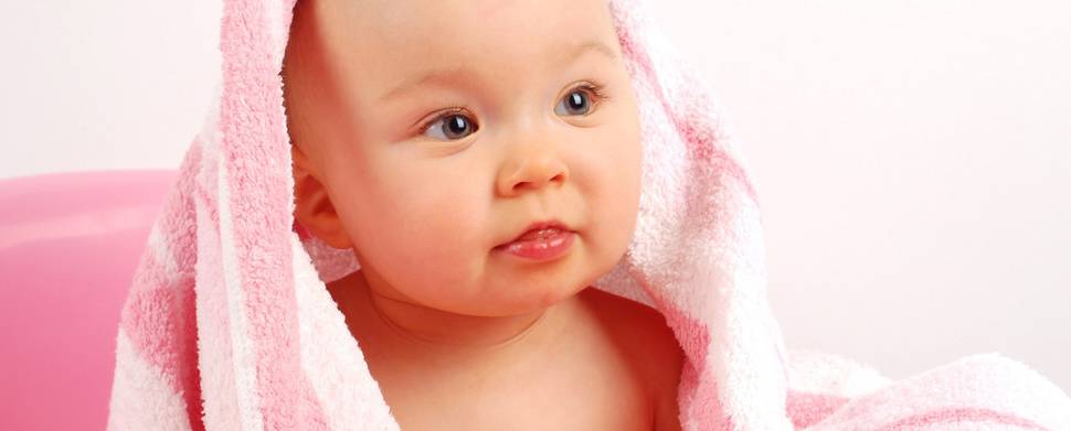 バスタオルを被ったお風呂あがりの赤ちゃんの写真