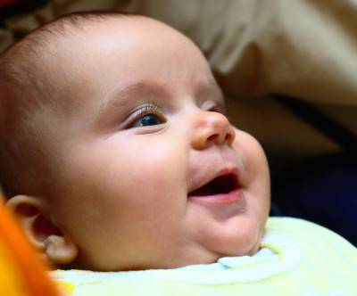 ベビーベッドで微笑む赤ん坊のキュートな写真