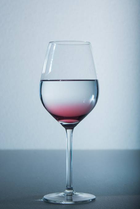 グラスの中の水とワインシロップの綺麗な写真