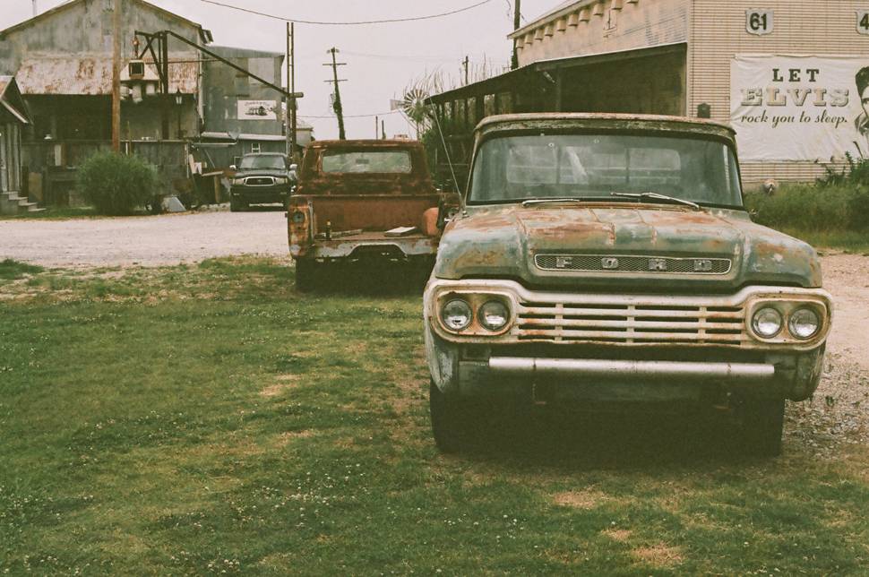ガレージの前のボロボロの中古車のレトロな写真